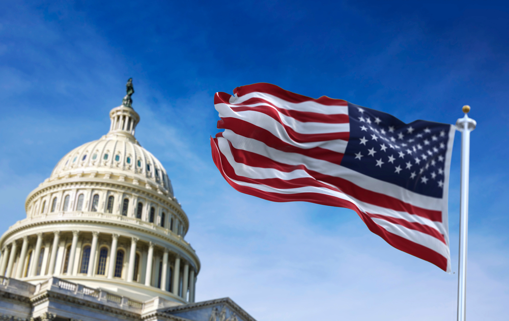 American flag waving with the US Capitol Hill in the background