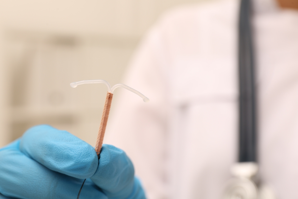doctor holding a paragard copper wound IUD with a blurred background